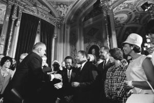 President Lyndon Johnson shakes hands with civil rights activists, including Dr. Martin Luther King Jr., after signing the Voting Rights Act of 1965. (Photo courtesy the LBJ Presidential Library)